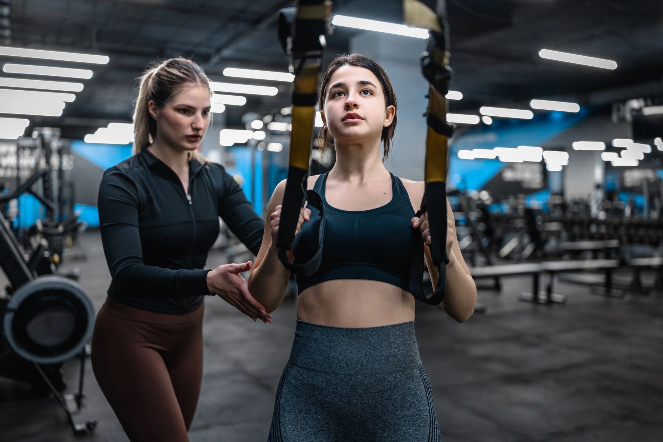 Personal trainer coaching a member in a modern gym